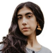 A headshot of Asalah Youssef, a female-presenting person, who poses for the camera.