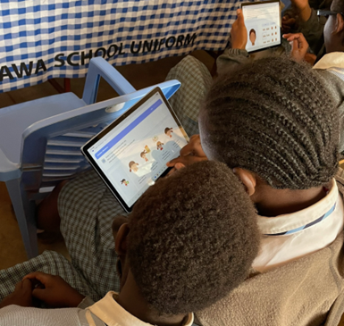 Photo of two students looking at an activity on a tablet.