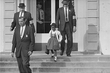 Photograph of Ruby Bridges being escorted to school by U.S. Marshalls